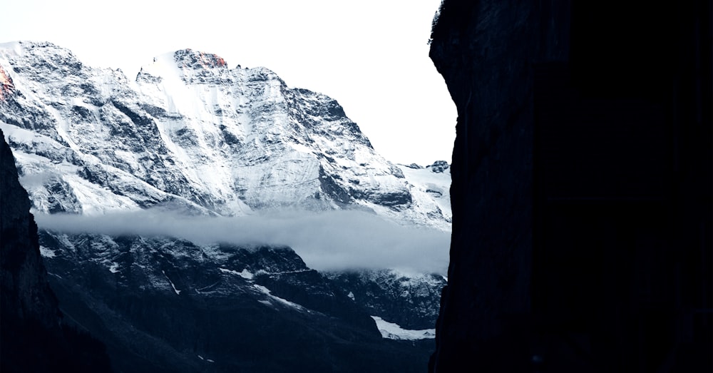 a snowy mountain with clouds