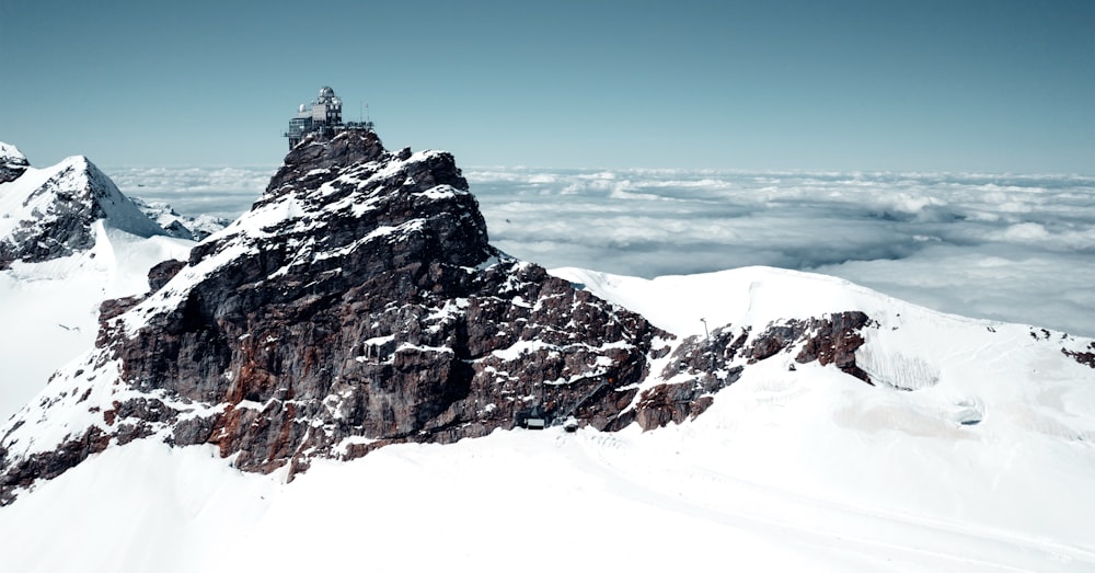 a snowy mountain with a building on top