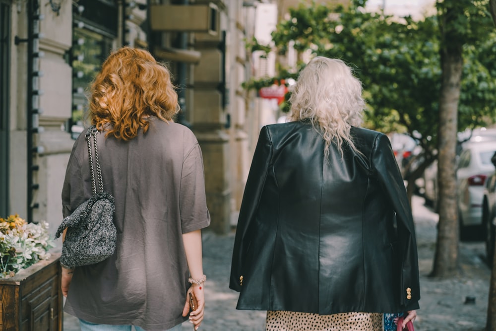 a couple of women walking down a sidewalk