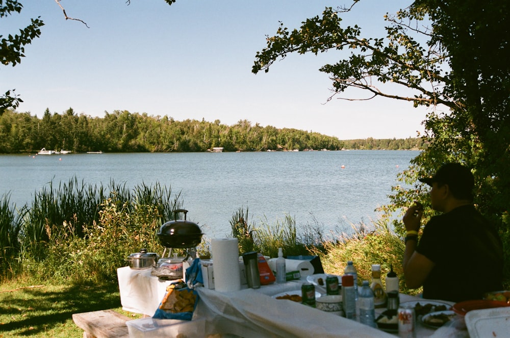 a table with food and drinks by a body of water