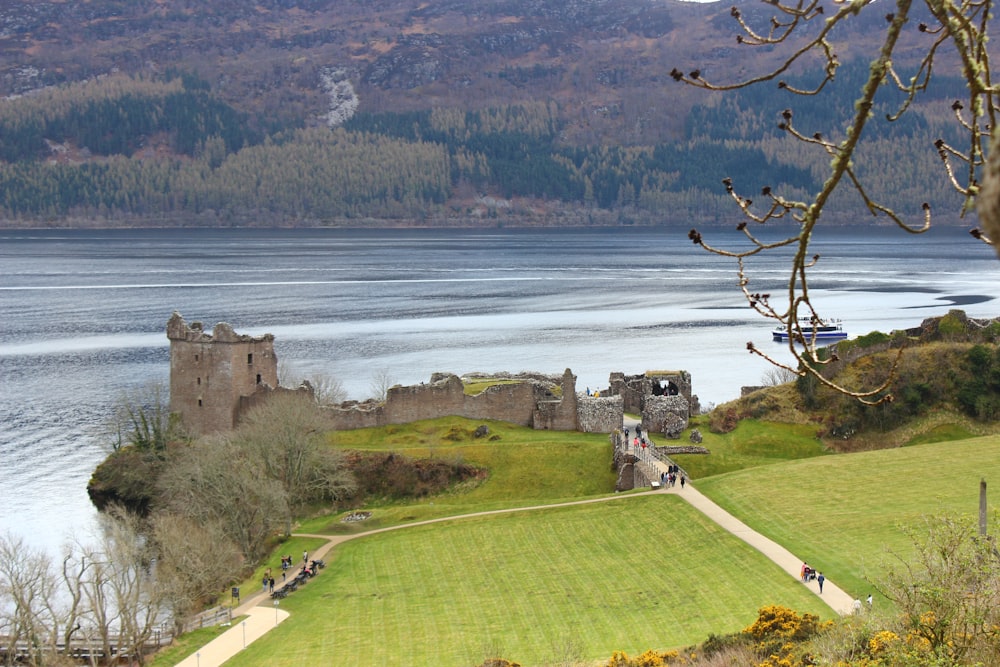 a castle on a hill by a lake