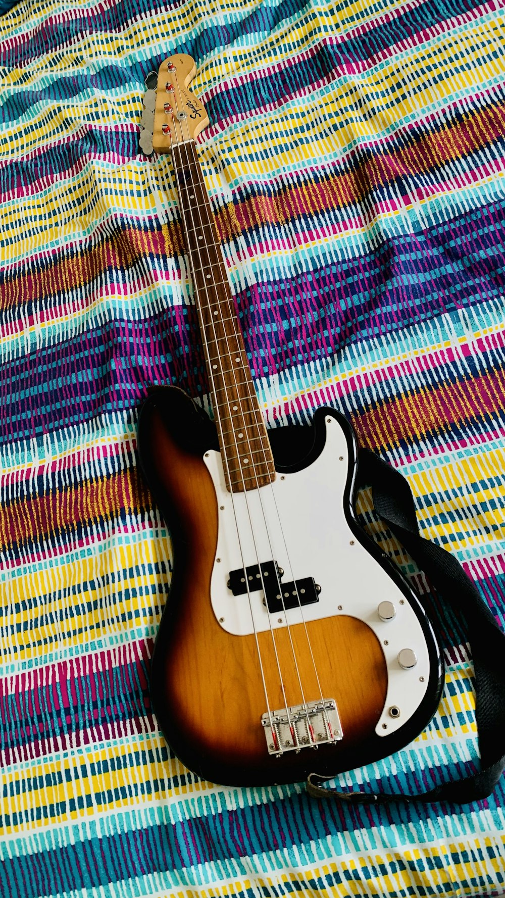 a guitar on a colorful blanket