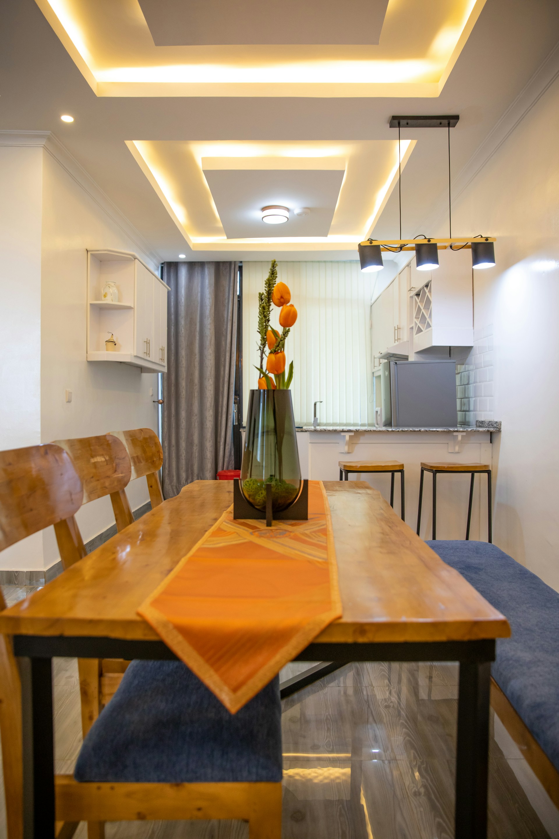 a dining room table with a vase of flowers on it