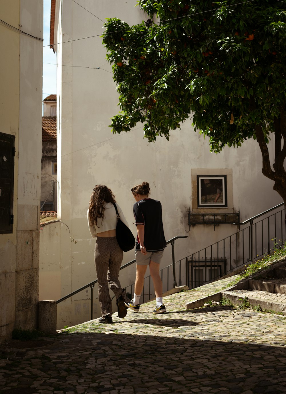 a couple of people walking down a sidewalk