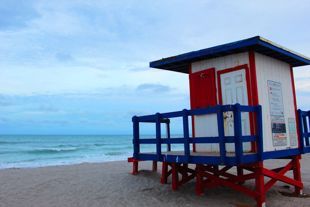 a small blue and white bench on a beach