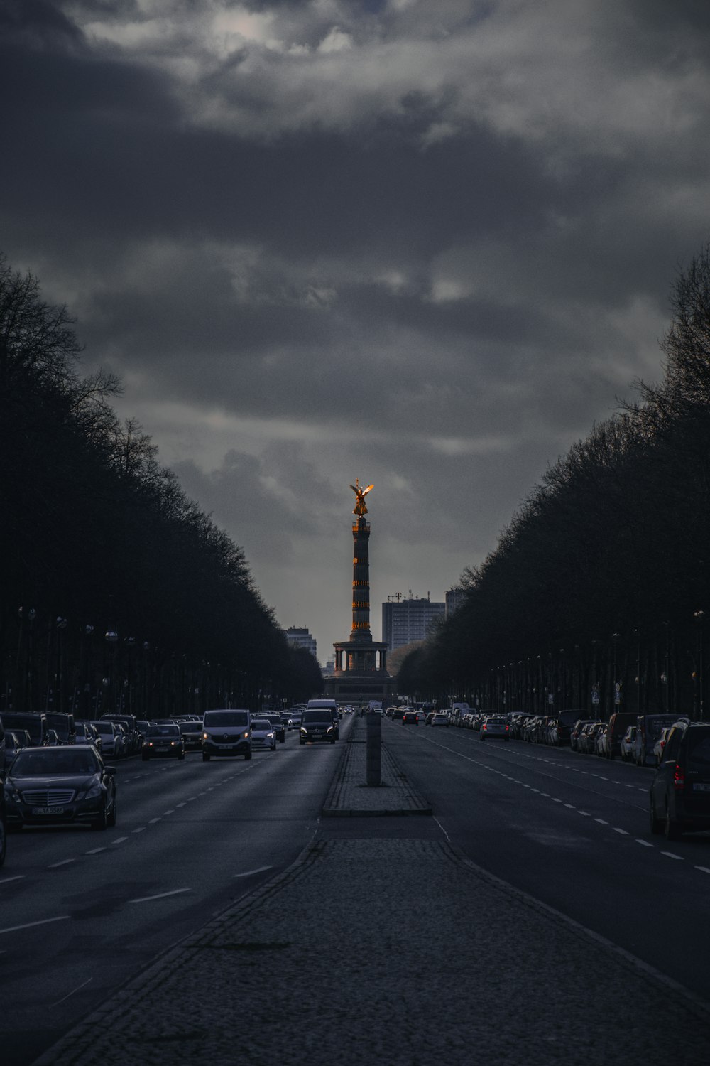 a road with cars on it and a tower in the distance