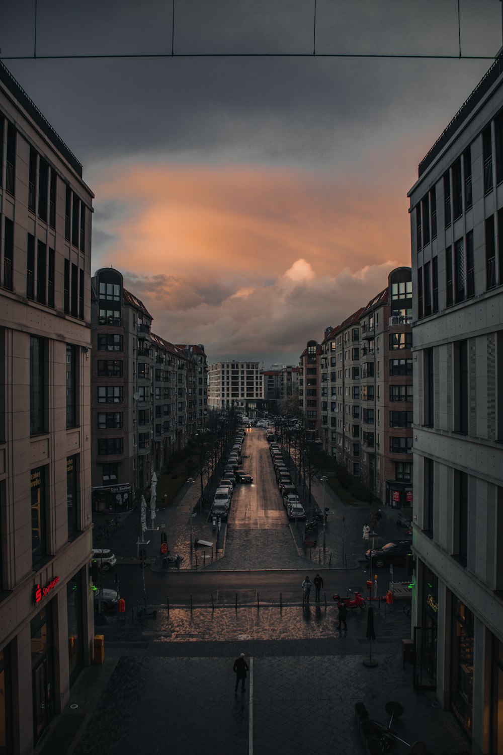 a city street with buildings and a sunset