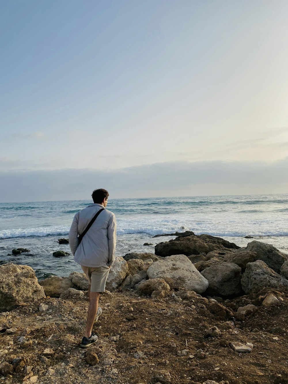 a man standing on a rocky beach