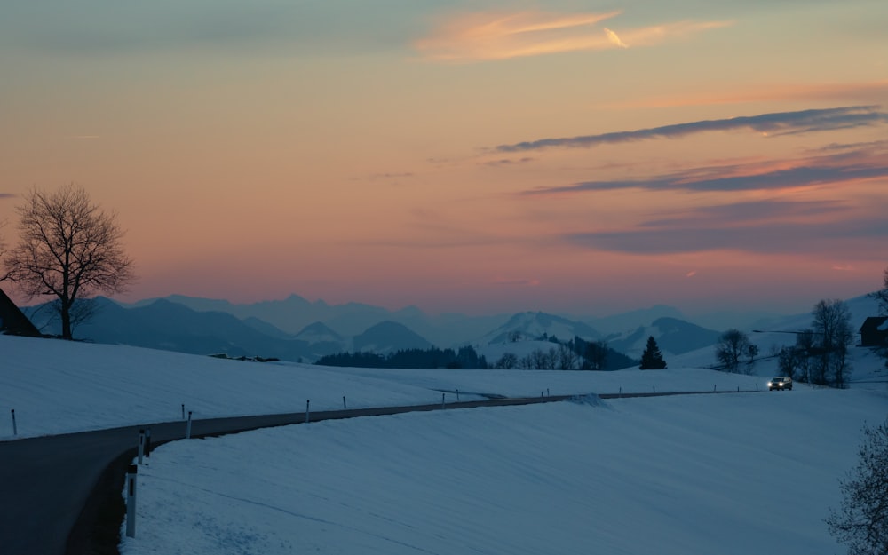 a snowy landscape with mountains in the background