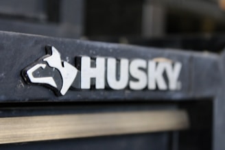 A close-up image of the Husky brand logo, featuring a stylized dog's head next to the word 'HUSKY' in bold, white letters against a dark background.