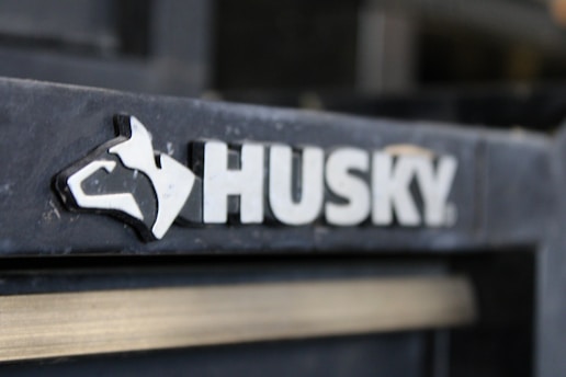 A close-up image of the Husky brand logo, featuring a stylized dog's head next to the word 'HUSKY' in bold, white letters against a dark background.