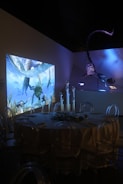 a room with a large screen and chairs