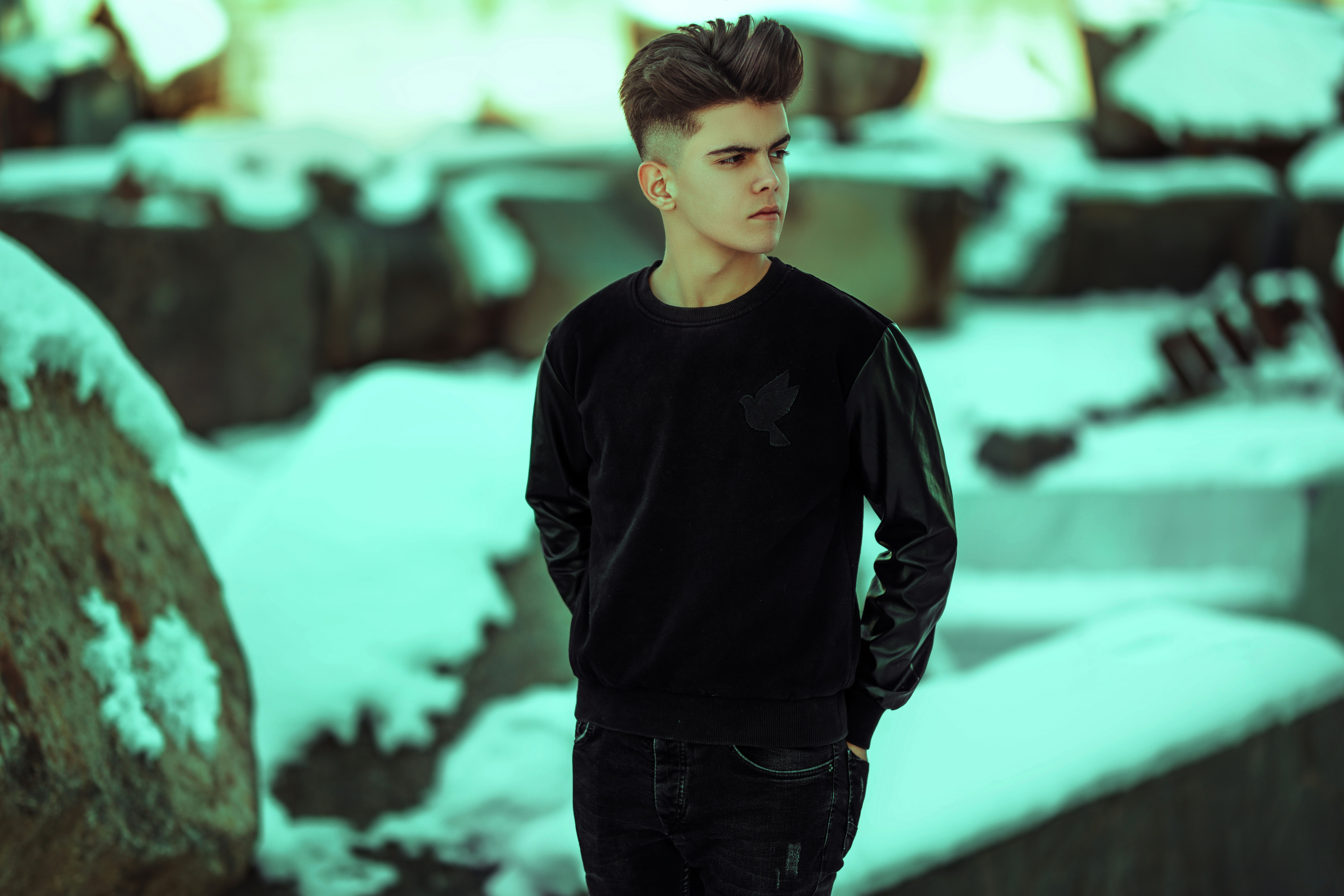 a man standing in front of a rock wall