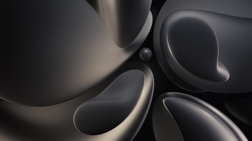 Smooth, dark, abstract shapes with a metallic sheen overlap and intertwine, creating a fluid, modern design. Soft gradients and rounded edges give a sense of depth and movement.