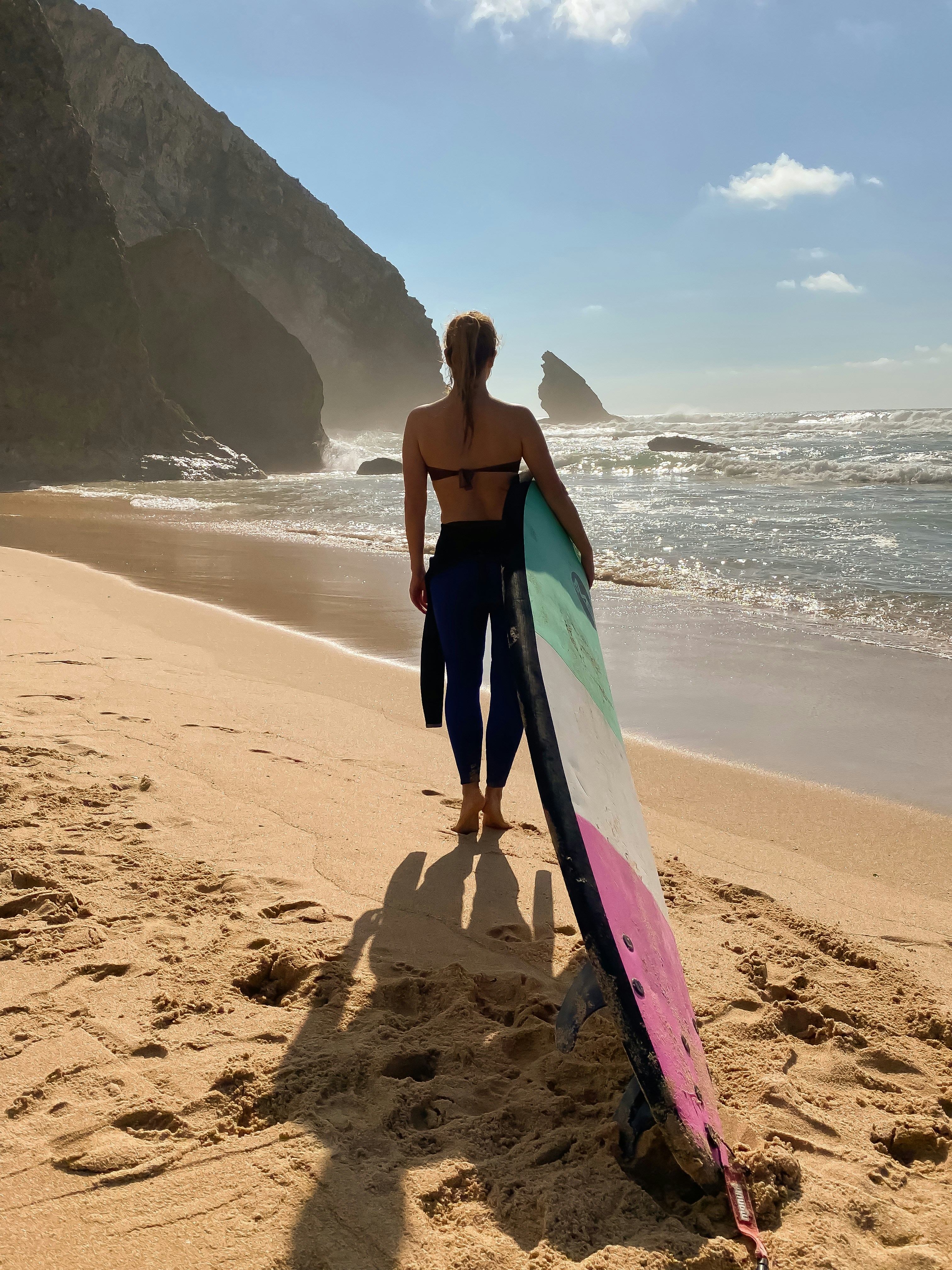 a person holding a surfboard on a beach