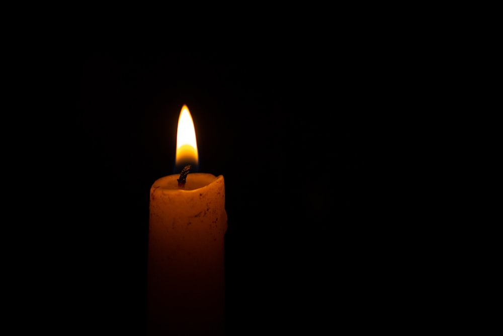 a lit candle in the dark