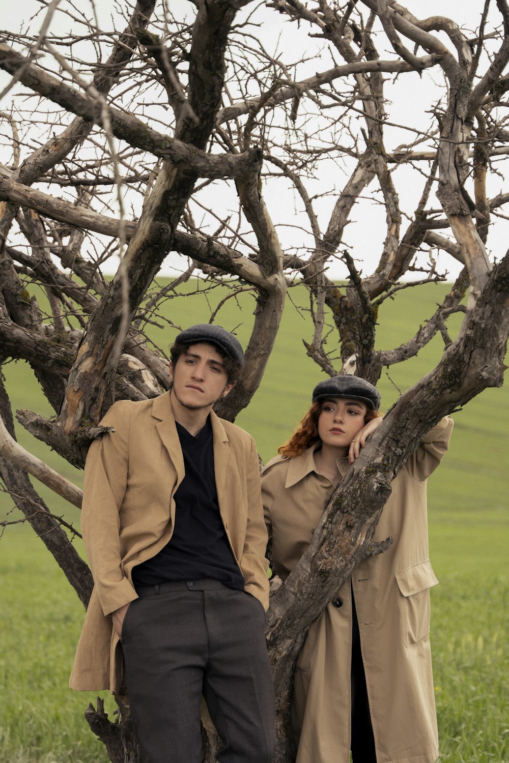 a man and woman standing under a tree