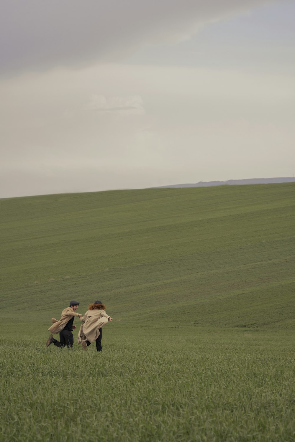 a couple of people sitting in a grassy field