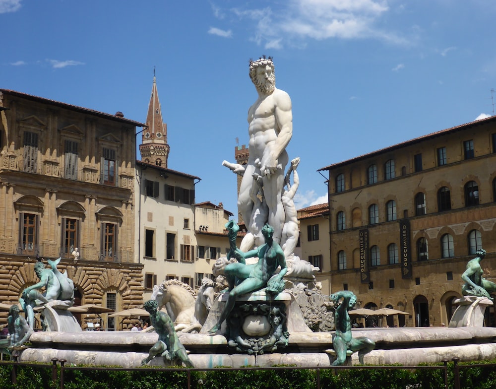 a statue in a courtyard with buildings in the background with Fountain of Neptune, Florence in the background