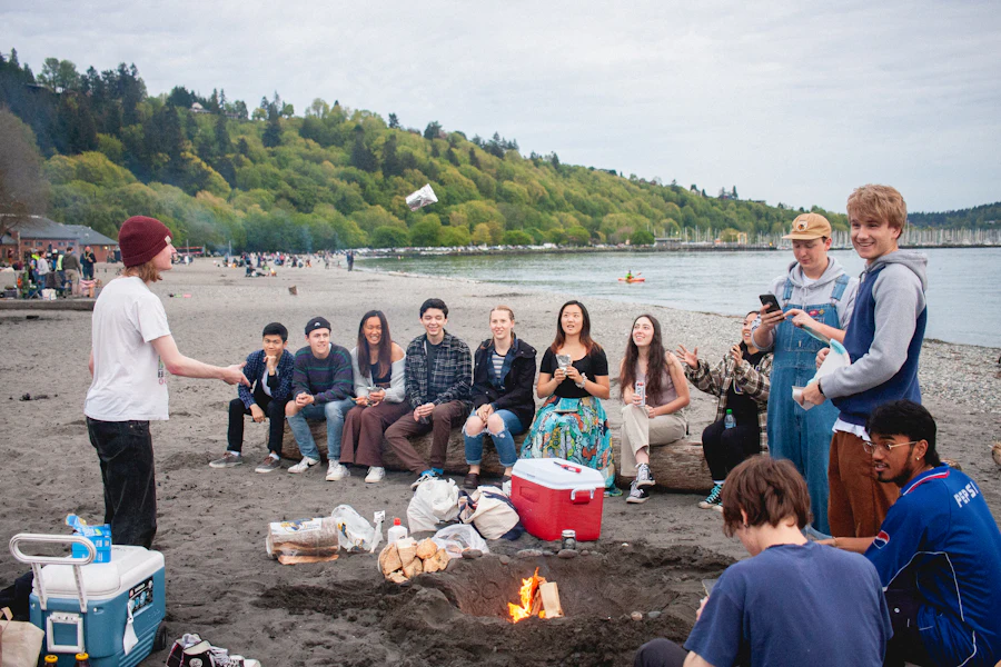 A community group sitting together on the sand at the beach