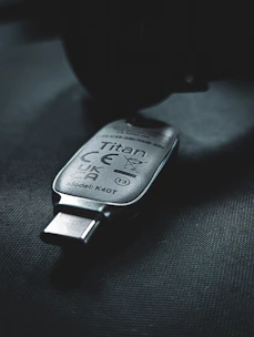 A secure token device used for storing digital certificates, placed on a wooden desk.