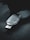 A USB security key marked with the name 'Titan', featuring various certification symbols and model number K40T, lies on a dark surface. The lighting creates a moody atmosphere with emphasis on the metallic texture of the key.