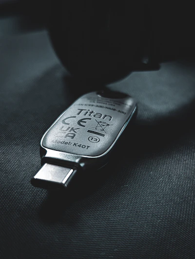 Close-up of a sleek hardware security key plugged into a laptop USB port, glowing softly.
