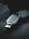 A USB security key marked with the name 'Titan', featuring various certification symbols and model number K40T, lies on a dark surface. The lighting creates a moody atmosphere with emphasis on the metallic texture of the key.