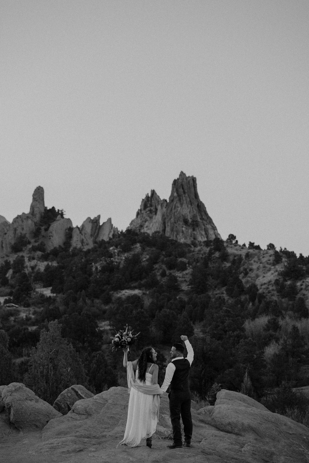 a man and woman kissing in front of a mountain