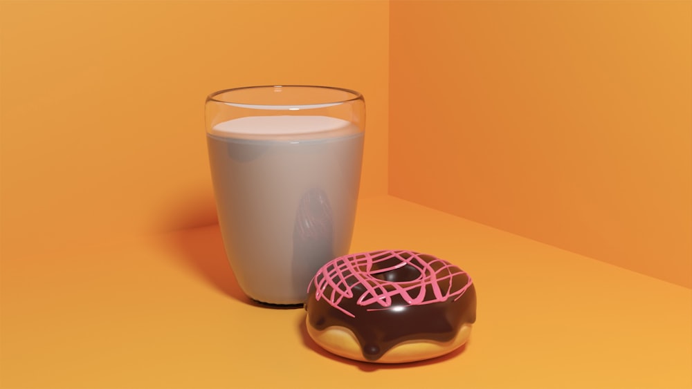a cup of coffee next to a donut and a cup