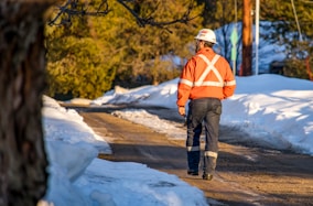 a man wearing a safety vest and standing on a road