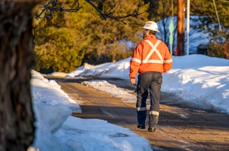 a man wearing a safety vest and standing on a road