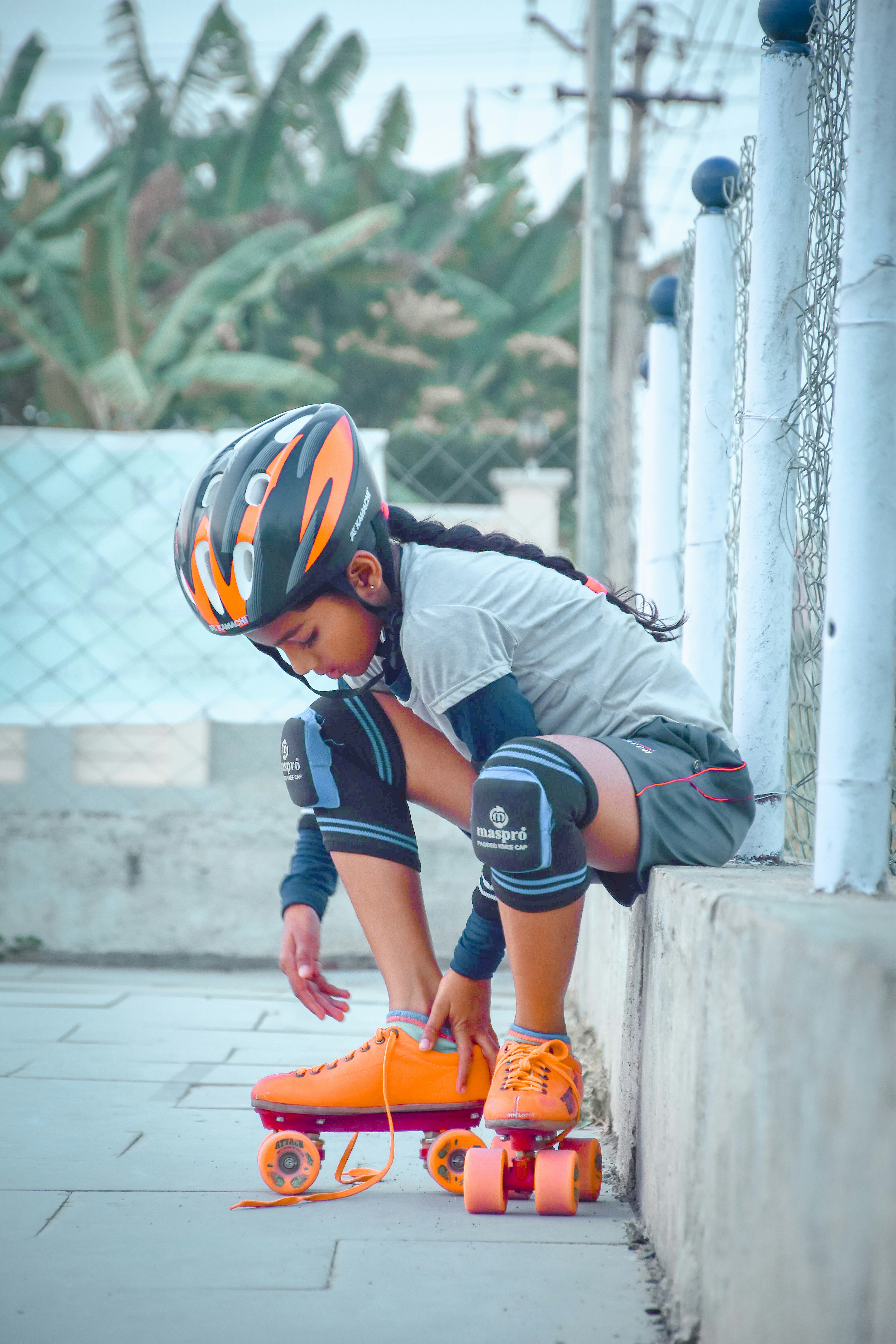 A girl laces up her roller skates.