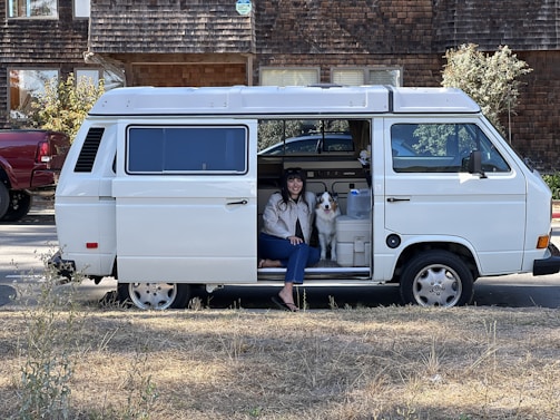 A cozy pet carrier inside the van with water and soft bedding for overnight care.