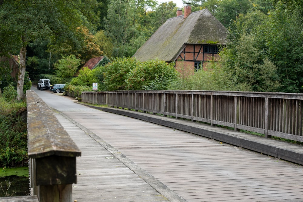 a wooden bridge with a building and trees in the background
