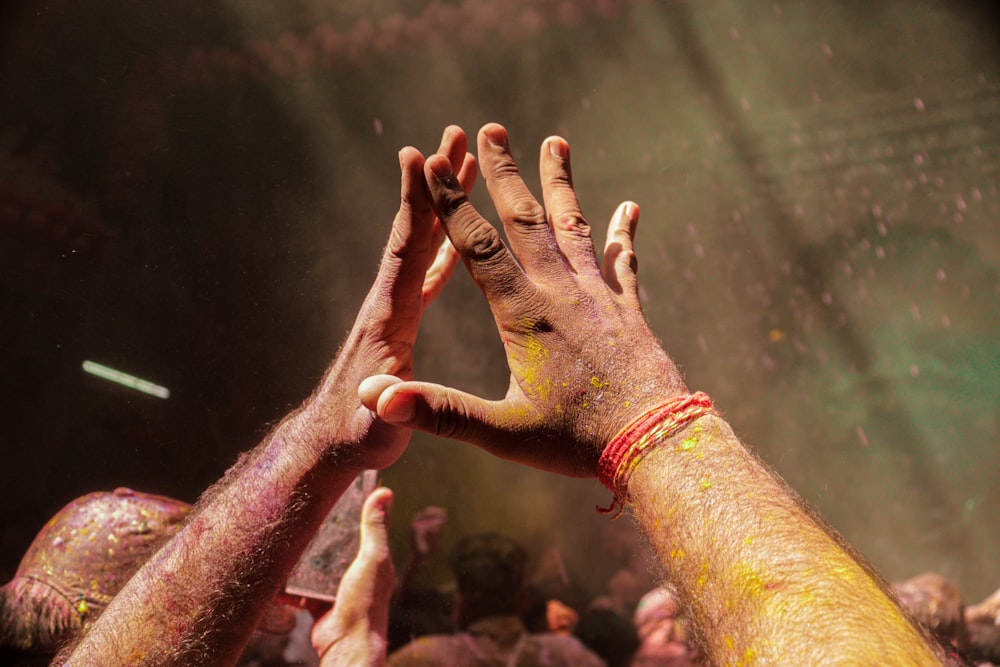 a group of hands with a crowd in the background