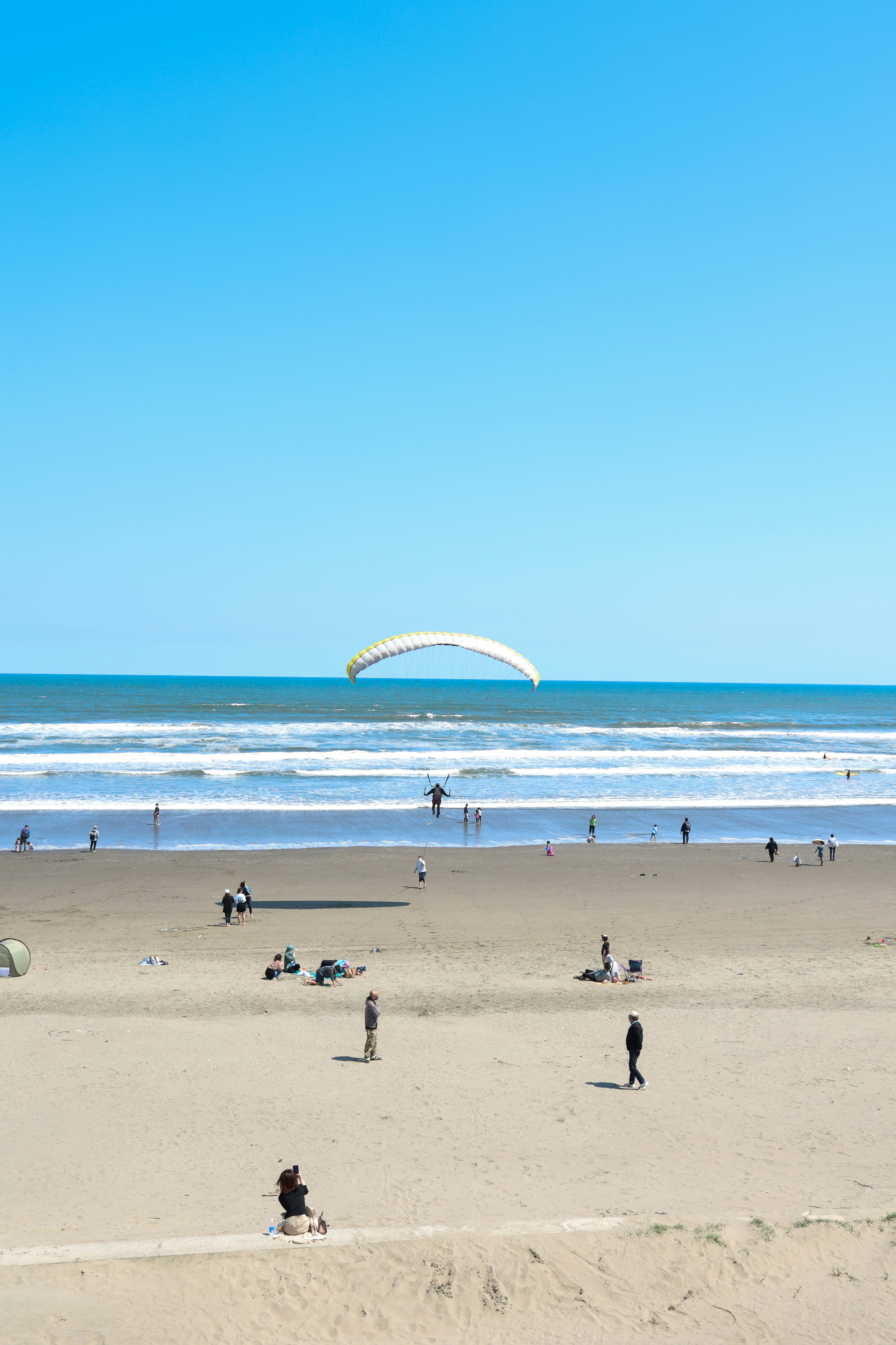 A group of people standing on top of a sandy beach photo – Free Blue ...