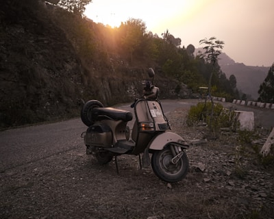 An outdoor scene with a classic Siambretta parked beside a rustic wall, bathed in golden hour light.