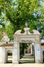 An artistic concrete archway leading into a themed area filled with greenery.