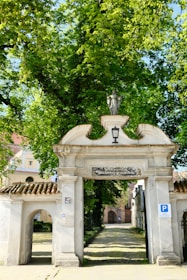 An artistic concrete archway leading into a themed area filled with greenery.