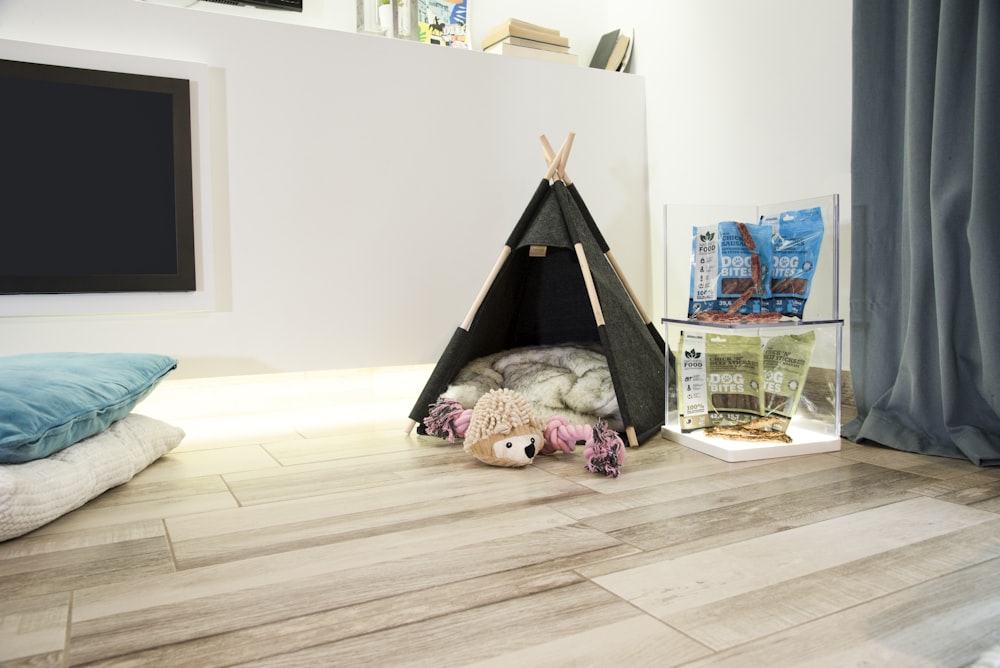 a dog lying on the floor next to a glass box and a toy