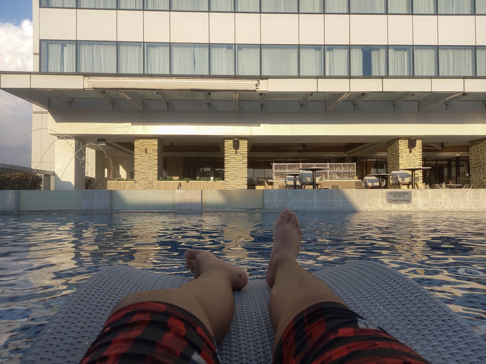 a person's feet on a ledge above a pool