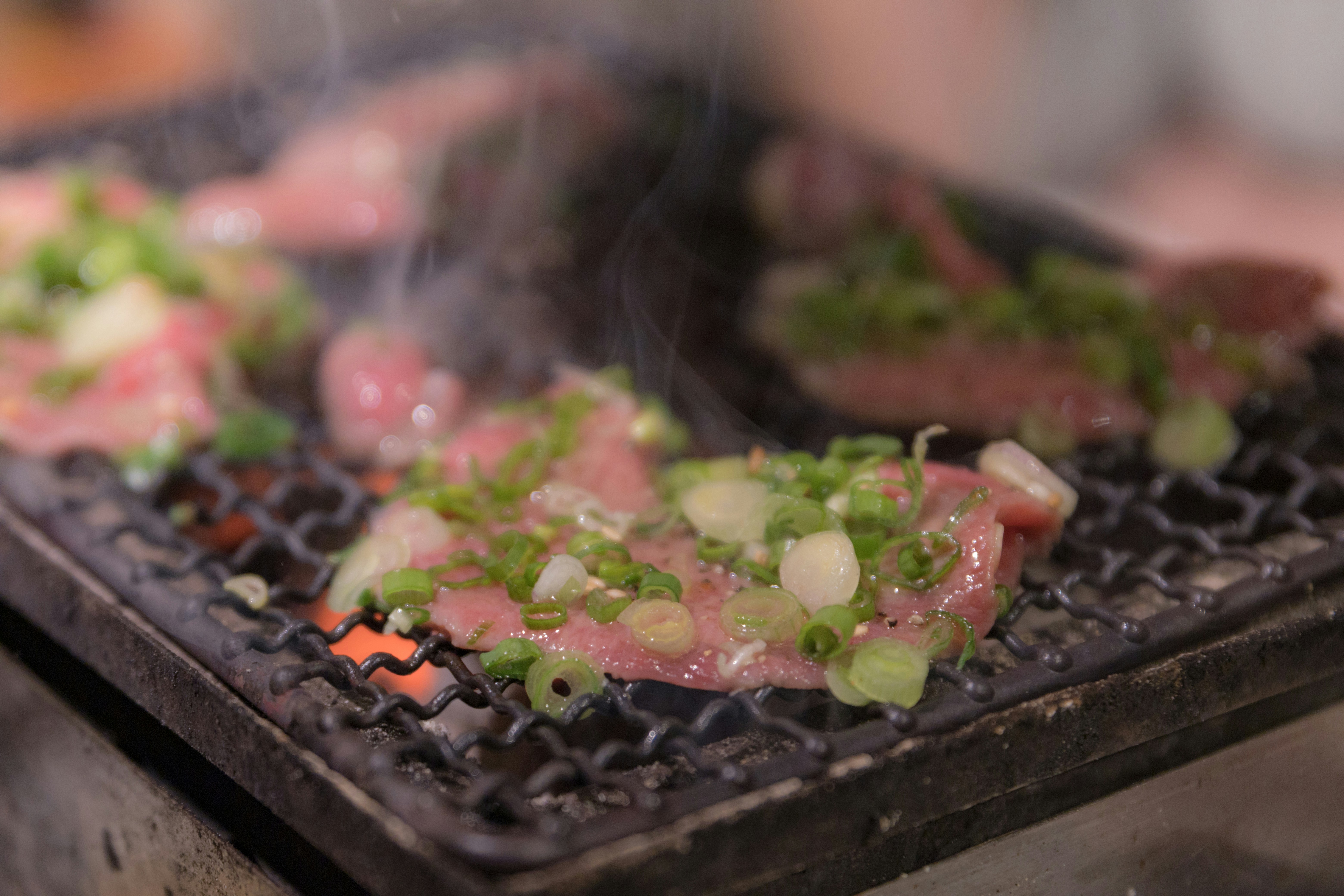 Close-up of meat cooking on a smoky grill