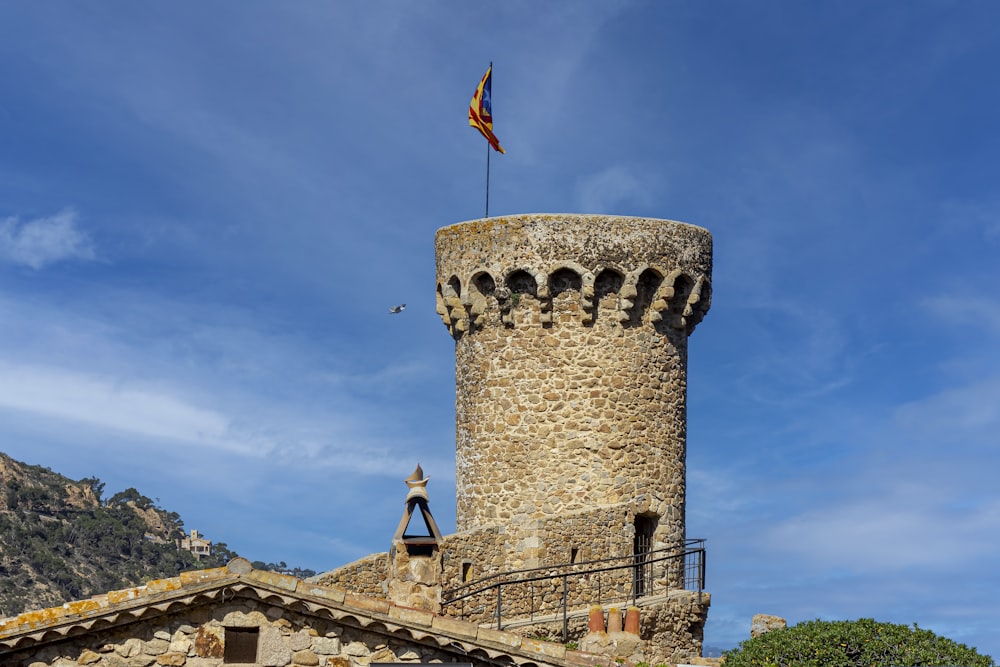 a stone tower with a flag on top