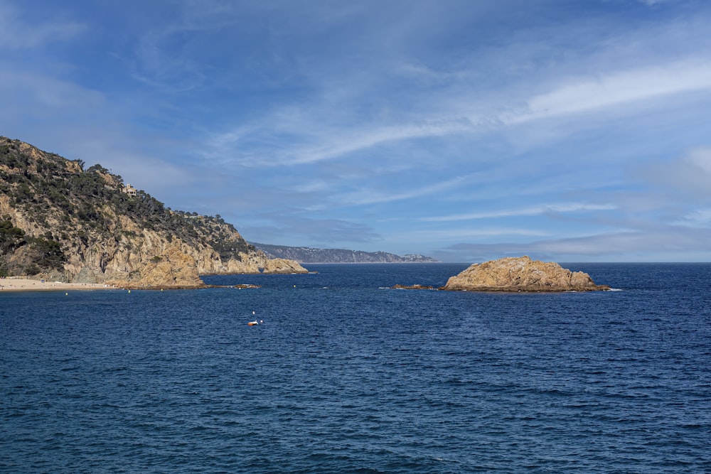 un plan d’eau avec un îlot rocheux au loin