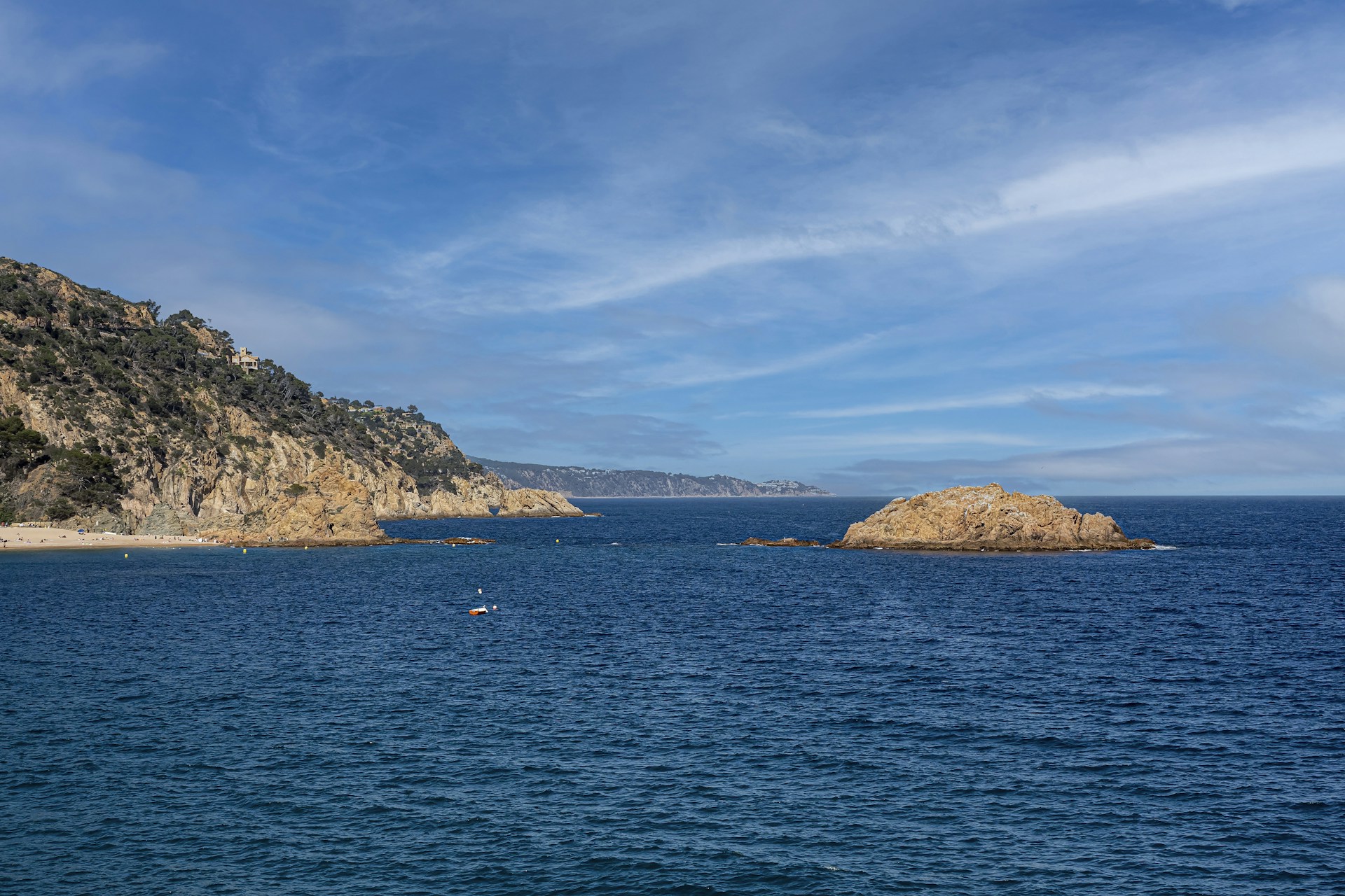 a body of water with a rocky island in the distance