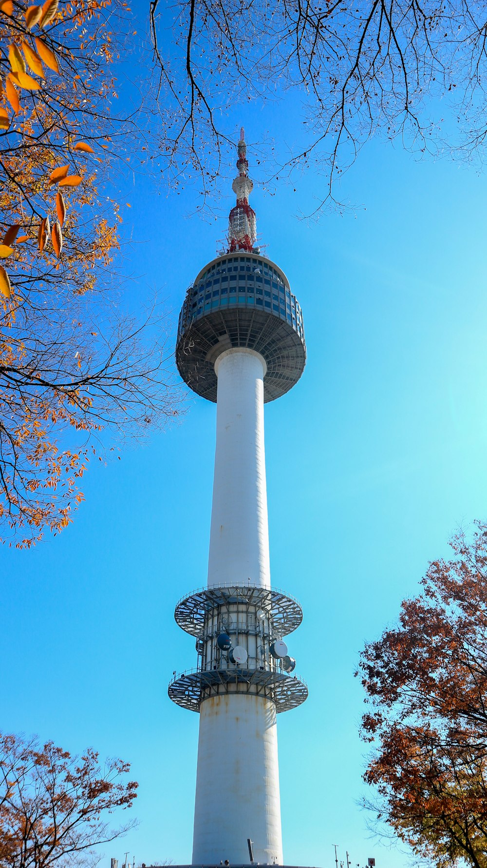 une haute tour avec un sommet pointu avec la tour N Séoul en arrière-plan