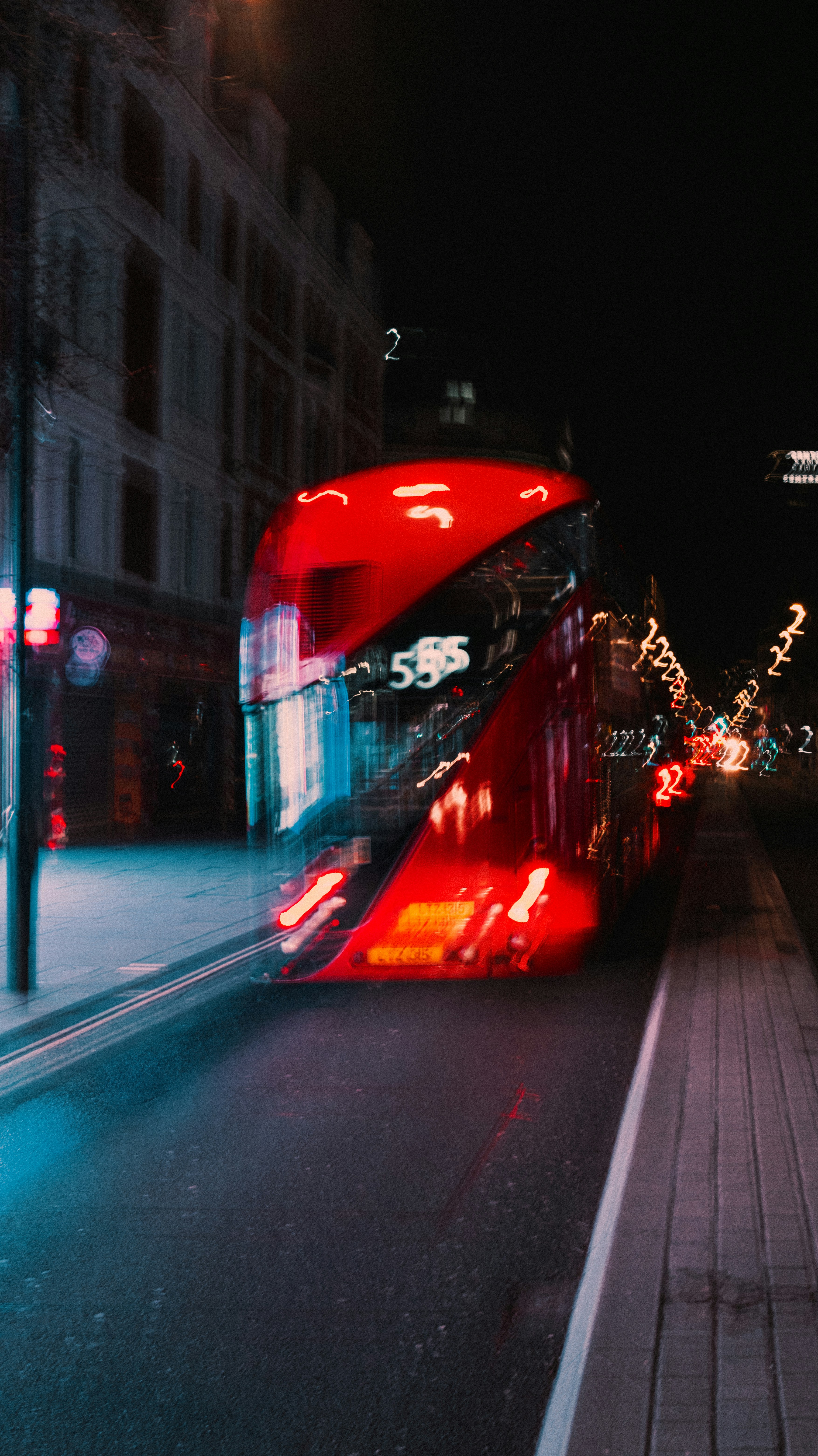 Night bus on a road with city lights in the background