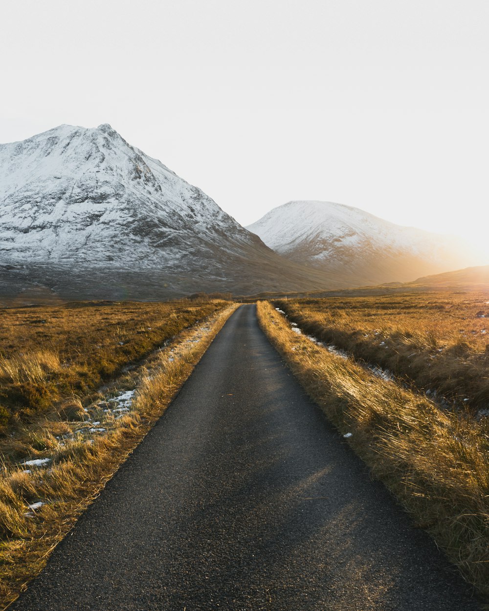 a road leading to a snowy mountain