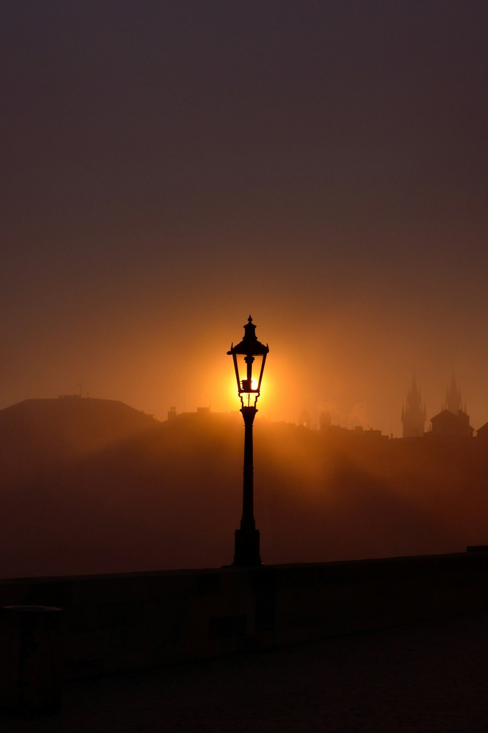 a lamp post with a city in the background